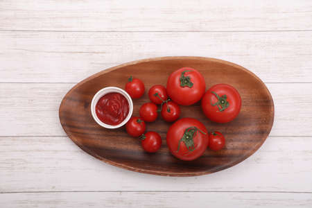 Tomato catchup and a tomato and the mini-tomato which I served in a plate.の写真素材