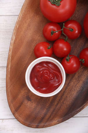 Tomato catchup and a tomato and the mini-tomato which I served in a plate.の写真素材