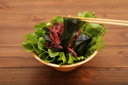 Salad with seaweed and chopsticks on wooden table, closeupの写真素材