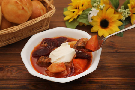 Traditional polish borscht soup with meat and vegetables on wooden backgroundの写真素材