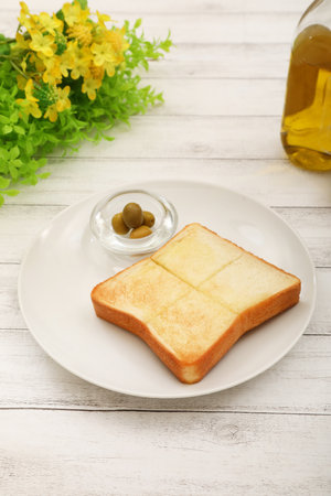 Breakfast with toast and oil on white wooden background, top viewの写真素材