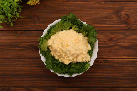 Top view of a bowl of Tartar sauce and lettuce salad on a wooden table.の写真素材