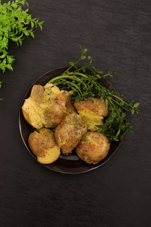 Smashed potatoes and watercress on a plateの写真素材