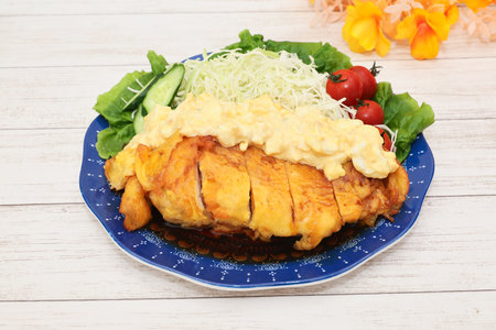 Crispy fried chicken breast with mayonnaise sauce and saladの写真素材