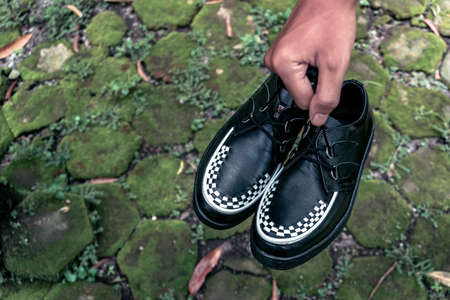 These black and white creepers shoes are made of leather and with black soles, these elegant and luxurious sneakers are handmade by home shoe craftsmenの写真素材
