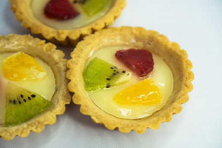 A plate of Indonesian snack called Pie Susu with toppings of oranges, strawberries and kiwi on a...