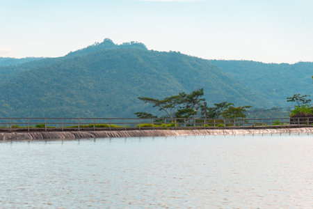 Reservoir on a vacant lot in countryside with view of wide hills and cloudy blue sky. as a natural water storage area when the dry season arrives, as well as a tourist locationの写真素材
