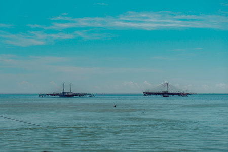Black sand beach in Talisayan, East Kalimantan which is receding, the waves are relatively calm and the sky is cloudyのeditorial素材