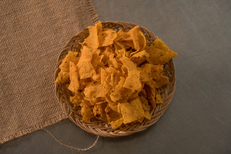 Tortilla chips served in a bamboo basket with a flat lay concept, the tortilla chips are fried...