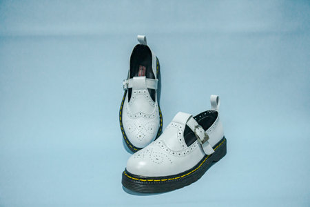 Detailed vintage mary jane rockabilly shoe in white color with a rubber outsole made of genuine cowhide with a neat pattern, very elegant and shiny against a turquoise backgroundの写真素材