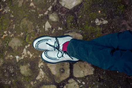 Close up of these white creepers sneakers made of genuine leather with black soles that men wear to sit on. These casual yet elegant shoes are handmade by home shoe craftsmenの写真素材