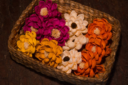 Close-up of colorful flowers in a rattan box to decorate the room. The interior of a boho style house consists of handcrafted flowers of various colorsの写真素材