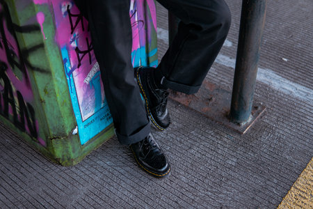 Close-up view of concept photo of full black wingtip brogue shoes made of genuine leather worn by...