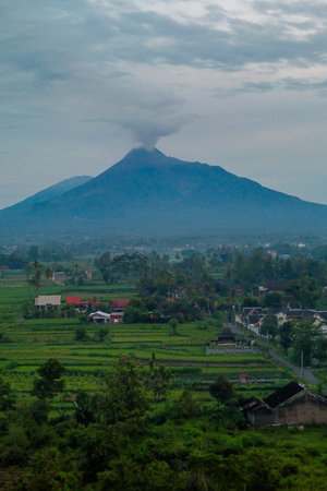 Aerial photo of the morning atmosphere in the countryside with a very majestic view of Mount Merapi visible in the distance. Morning atmosphere with a volcano in the backgroundの写真素材