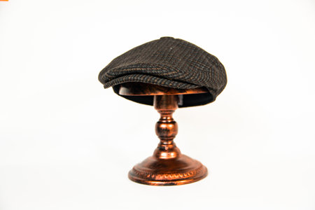 Detail of a paddy or gatsby hat made of wool fabric with a pattern in a white background. Classic newsboy hat photo concept on an elegant bronze mannequinの写真素材