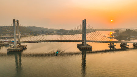 Aerial photo at sunset from the Kendari Bay Bridge which is the icon of the city. Aerial panorama at dusk of the suspension bridge that connects the two lands and divides the bayの写真素材