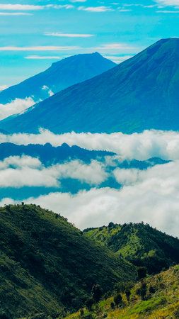 Landscape of Mount Sindoro seen from the peak of Mount Prau on a clear morning. Panorama of Mount Sindoro with the peak of Mount Prau in the foreground.の写真素材