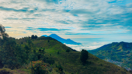 Landscape of Mount Sindoro seen from the peak of Mount Prau on a clear morning. Panorama of Mount Sindoro with the peak of Mount Prau in the foreground.の写真素材