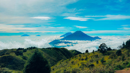 Landscape of Mount Sindoro seen from the peak of Mount Prau on a clear morning. Panorama of Mount Sindoro with the peak of Mount Prau in the foreground.の写真素材