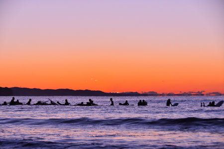 Surfer waiting for the sunrise (silhouette)の写真素材