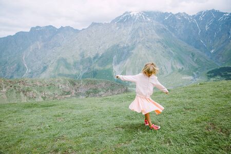 Little girl in pink dress swirling in the mountains of Georgiaの写真素材