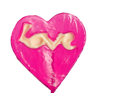 crimson lollipop in the shape of a heart on a stick