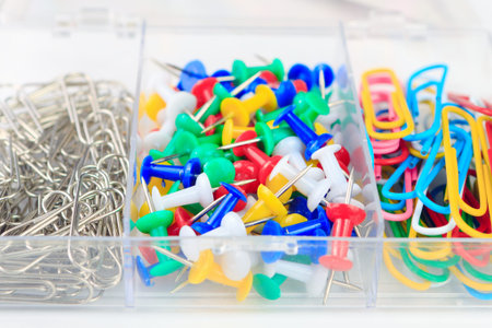 office supplies in a box, set of stationery, multicolored paper clips and buttons stationery
