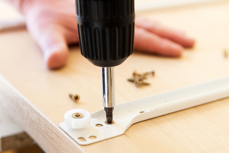 man collects furniture fittings, drill guides to chipboardの写真素材