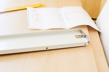 metal furniture accessories and drawings lay on chipboard