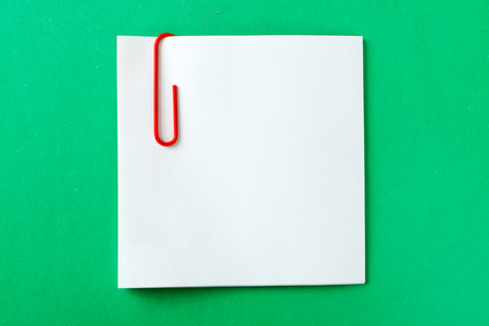 a recording sheet with a red paper clip on a green backgroundの写真素材