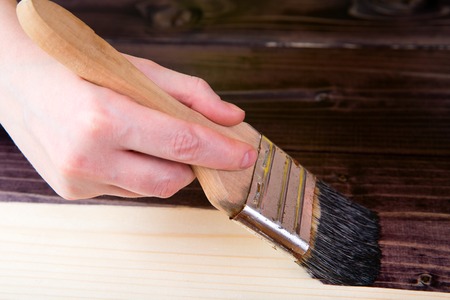 Tinting in the dark color of wood with a brush. Protection of wood from insects and corrosionの写真素材