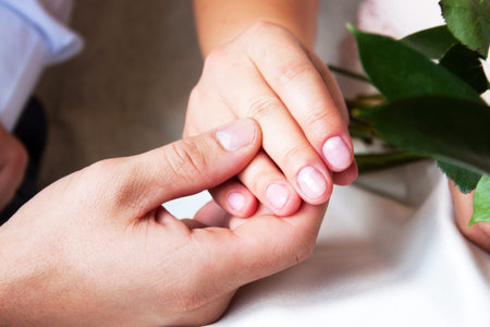 couple sitting holding hands with womans hand on top