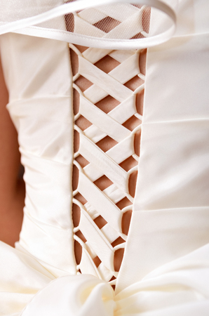 Satin lacing on the wedding dress of the bride. View from the back.の写真素材