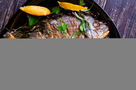 Fried gilthead with juicy fresh lemon and rice garnish and tomatoes close-up