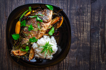 Baked dorada with juicy fresh lemon and rice garnish close-up
