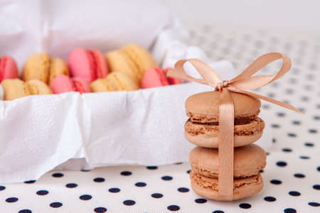 Macaroni cakes with vanilla and chocolate filling close-up tied with a ribbon.の写真素材