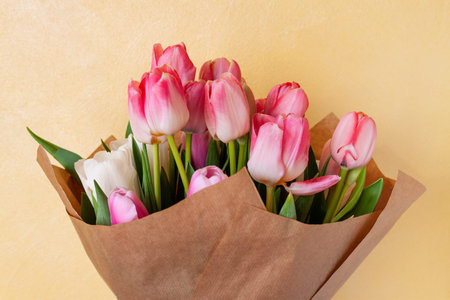 Bouquet of delicate pink and white tulips in paper on a light yellow background.の写真素材