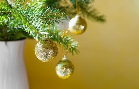 Fir branches with shiny golden toys in a vaseの写真素材