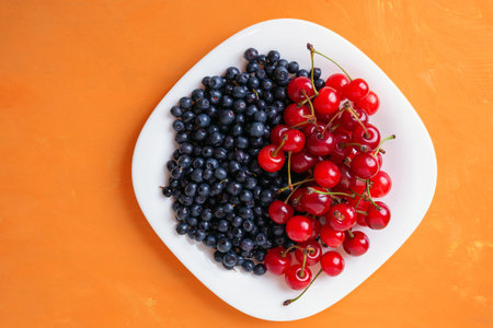 berries of ripe cherries and blueberries on a plate, summer seasonal berriesの写真素材