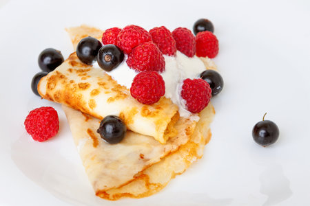Thin pancakes with currant and berry sauceの写真素材