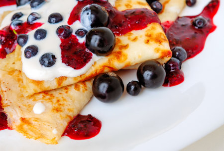 Thin pancakes with sweet currant and berry sauce close-upの写真素材