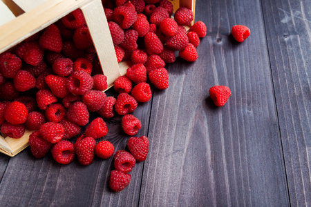Ripe fresh raspberries in a basket on a black backgroundの写真素材