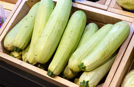 The zucchini is light green in color neatly stacked in a wooden boxの写真素材