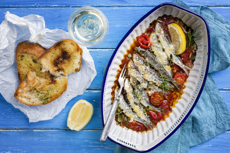 Sardinas en salsa with garlic bead as top view in a skillet の写真素材