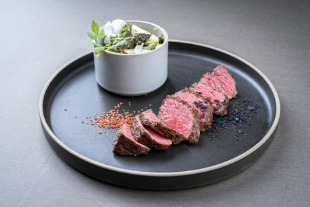 Modern barbecue dry aged sliced fillet steak spring salad with and green and white asparagus as closeup on a plateの写真素材