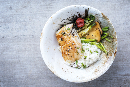 Modern Japanese fried cod fish filet with green asparagus and rice as top view in a bowl with copy space leftの写真素材
