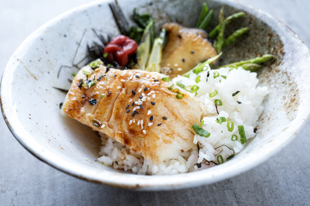 Modern Japanese fried cod fish filet with green asparagus and rice as top view in a bowlの写真素材