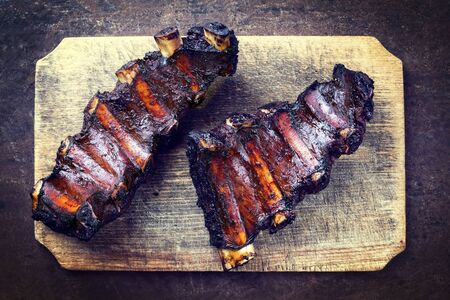 Barbecue chuck beef ribs with hot marinade as top view on a wooden cutting boardの写真素材