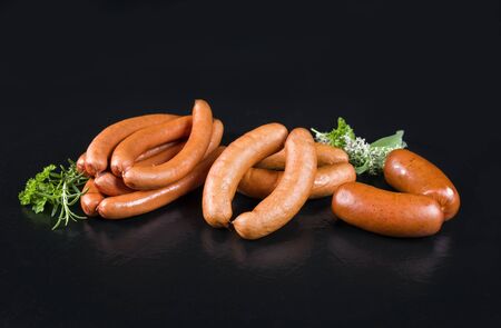 Traditional German sausages for BBQ, fry and cooking as closeup on a black board with copy spaceの写真素材