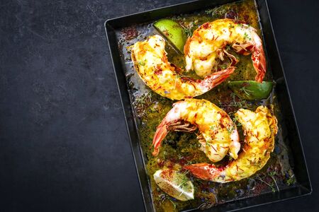 Traditional barbecue spiny lobster tail sliced and offered with saffron lemon sauce as top view on a metal tray with copy space left の写真素材